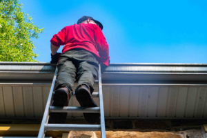 Man leaning against gutters with latter.