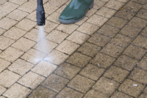 Close-up of person power washing brick.