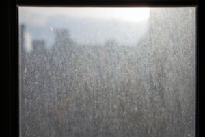 Window covered in dust and water marks.
