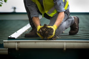 Man picking up debris from gutter.