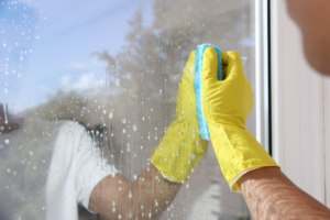 Man wipping window with sponge.